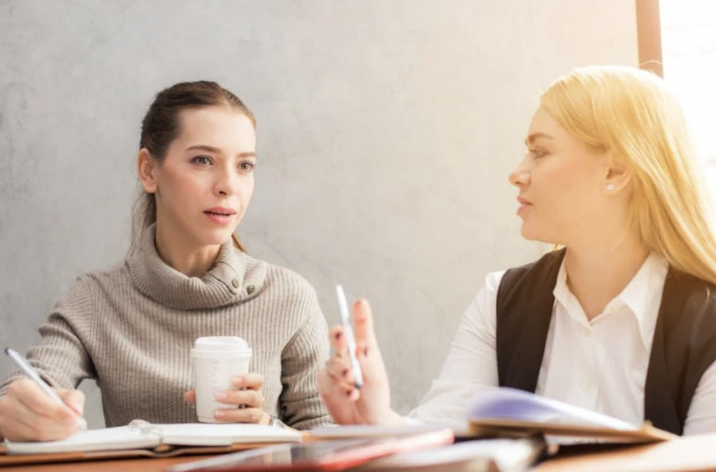 2 Business Women Sitting at a Conference Table